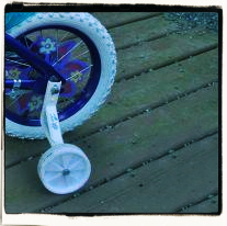 Child bicycle with training wheels and flowers in the spokes